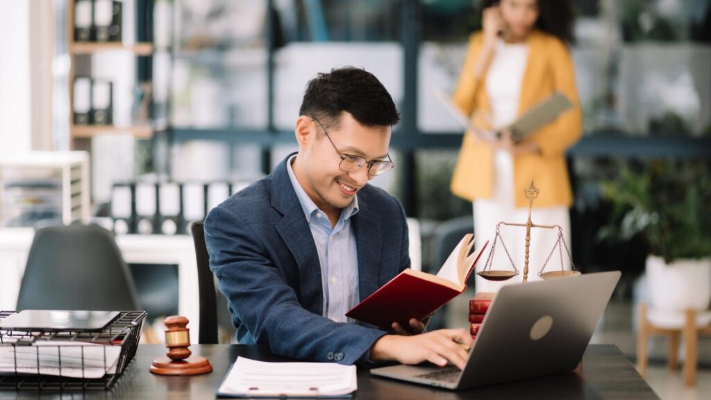 Attorney on laptop in office smiling